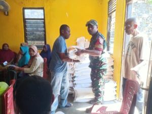 Sertu Muhajir Moka Dampingi Distribusi Bantuan Pangan di Desa Lewalu