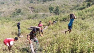Pos Fohuk Satgas Yonif 741/GN Dukung Kegiatan Adat Dengan Gotong Royong Siapkan Kayu Bakar Bersama Pemuda Desa