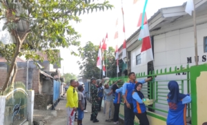 Babinsa Talabiu Dampingi Mahasiswa dan Warga Bersihkan Parit Musholla