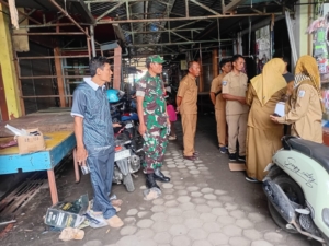 Babinsa Kelurahan Dalam Dampingi Pembagian Kupon Lokasi Baru Pedagang Pasar Tana Mira