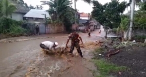 “Gerak Cepat Babinsa Aikmel Atasi Luapan Air Sungai di Kembang Kerang Induk”