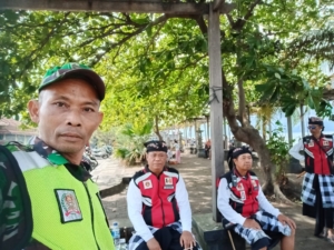 Babinsa Nagasepaha Jaga Kekhidmatan Prosesi Melasti Menuju Pantai Pelabuhan Buleleng