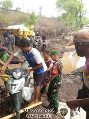 Jalan Rusak dan Banjir, Babinsa Koramil Donggo Inisiatif Bantu Warga Lewati Sungai So Nampa