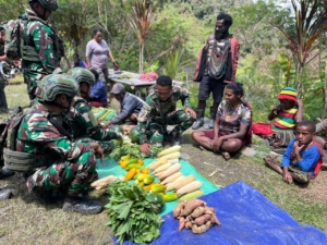 Prajurit Satgas Yonif 743/PSY Pos Merah Putih kembali menunjukkan kepedulian mereka terhadap masyarakat dengan melaksanakan kegiatan belanja kasih atau pembelian hasil bumi milik para Mama Papua di Kampung Ginnik, Distrik Mulia, Kab. Puncak Jaya, Papua, Rabu (19/11/25).  Kegiatan sederhana namun sarat makna ini menjadi salah satu bentuk nyata dukungan Satgas Yonif 743/PSY  terhadap ekonomi keluarga serta penguatan hubungan kekeluargaan dengan masyarakat setempat.  Danpos Merah Putih, Letda Inf Danuja, mengatakan bahwa kegiatan tersebut merupakan bagian dari komitmen Satgas untuk hadir sebagai saudara bagi masyarakat Papua.  “Kami membeli langsung sayur-sayuran hasil kebun Mama Papua sebagai bentuk dukungan nyata. Harapan kami, aktivitas kecil ini dapat membantu perekonomian keluarga sekaligus mempererat kedekatan antara TNI dan masyarakat,” ujarnya.  Salah satu Mama Papua, Mama Mei Talenggen, tak kuasa menyembunyikan rasa syukurnya ketika hasil kebunnya dibeli oleh Satgas. “Terima kasih Anak-anak Pos, sa senang sekali sudah beli sayur, semoga di berkati” ucapnya tulus.  Kegiatan borong hasil bumi ini akan terus dilaksanakan secara berkelanjutan sebagai langkah konkret Satgas Yonif 743/PSY dalam mewujudkan kemanunggalan TNI dan rakyat, serta menghadirkan kehadiran yang membawa dampak nyata bagi kesejahteraan masyarakat di tanah Papua.