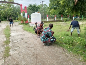 Anggota Satgaster Pos Halibete Bersama Warga Gotong Royong Bersihkan Halaman Kantor Desa