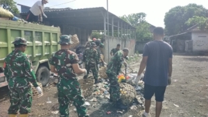 Babinsa dan Warga Sesela Bersihkan TPS Pasar