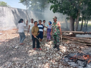Budayakan Gotong Royong, Babinsa Bersama Warga Bersihkan Lingkungan Kantor Desa