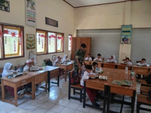 Babinsa Taliwang Dampingi Anak SD Nikmati Makan Bergizi Gratis