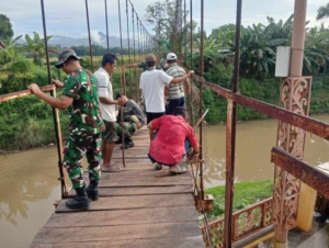 Anggota Koramil dan Masyarakat Lakukan Pembongkaran Awal Jembatan di Rontu