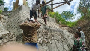 Babinsa Waingapu Bersama Warga Gotong Royong Pasang Pondasi Jembatan Garuda di Kambatatana